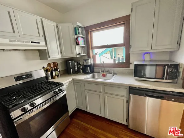 a kitchen with stainless steel appliances a sink a stove and cabinets
