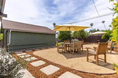 a view of a patio with a table and chairs under an umbrella