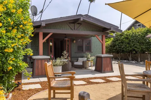 a view of a patio with a table and chairs under an umbrella