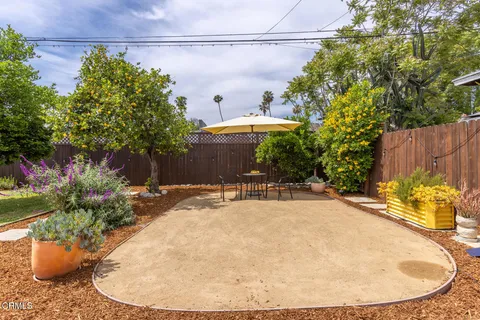 a view of a patio with a table and chairs under an umbrella