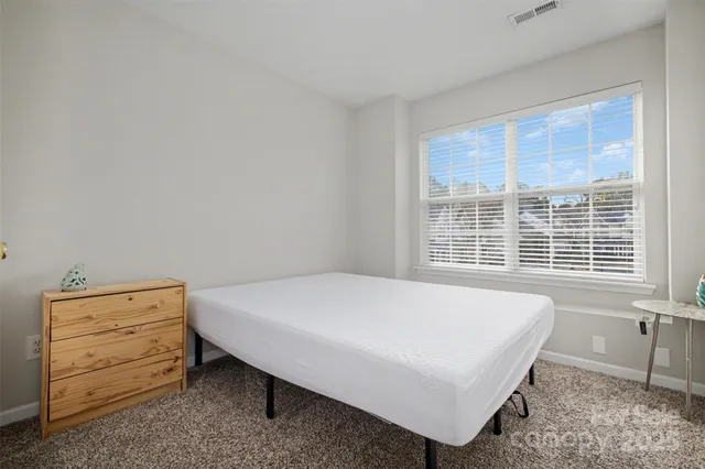 a bed sitting in a bedroom next to a window