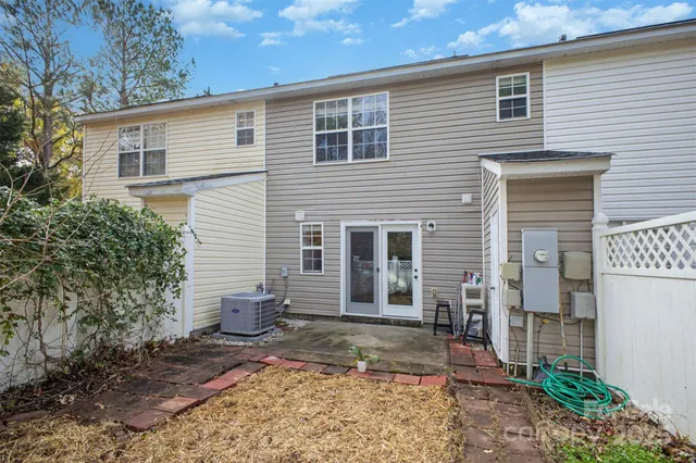 a view of a backyard with plants and large tree