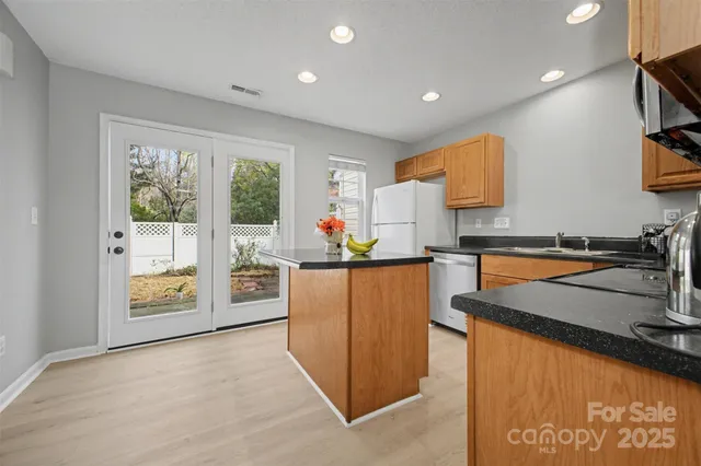 a kitchen with stainless steel appliances granite countertop a refrigerator and a stove top oven