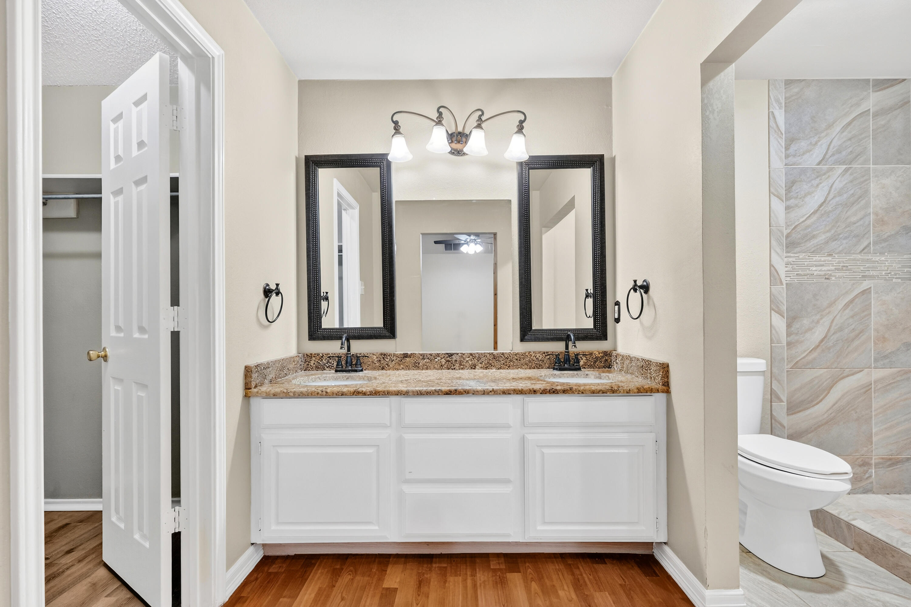 2415 93rd Street Lubbock, TX 79423 - Photo 14 of 24 a bathroom with a granite countertop sink mirror and a toilet