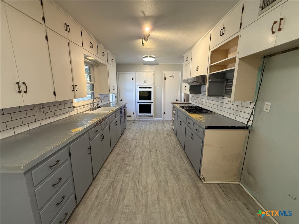 1701 North 13th Street Temple, TX 76501 - Photo 12 of 48 a kitchen with granite countertop a sink stove and cabinets