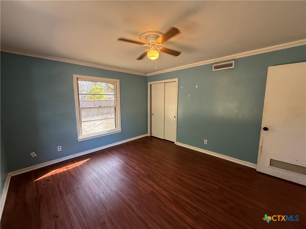 1701 North 13th Street Temple, TX 76501 - Photo 16 of 48 an empty room with wooden floor fan and windows