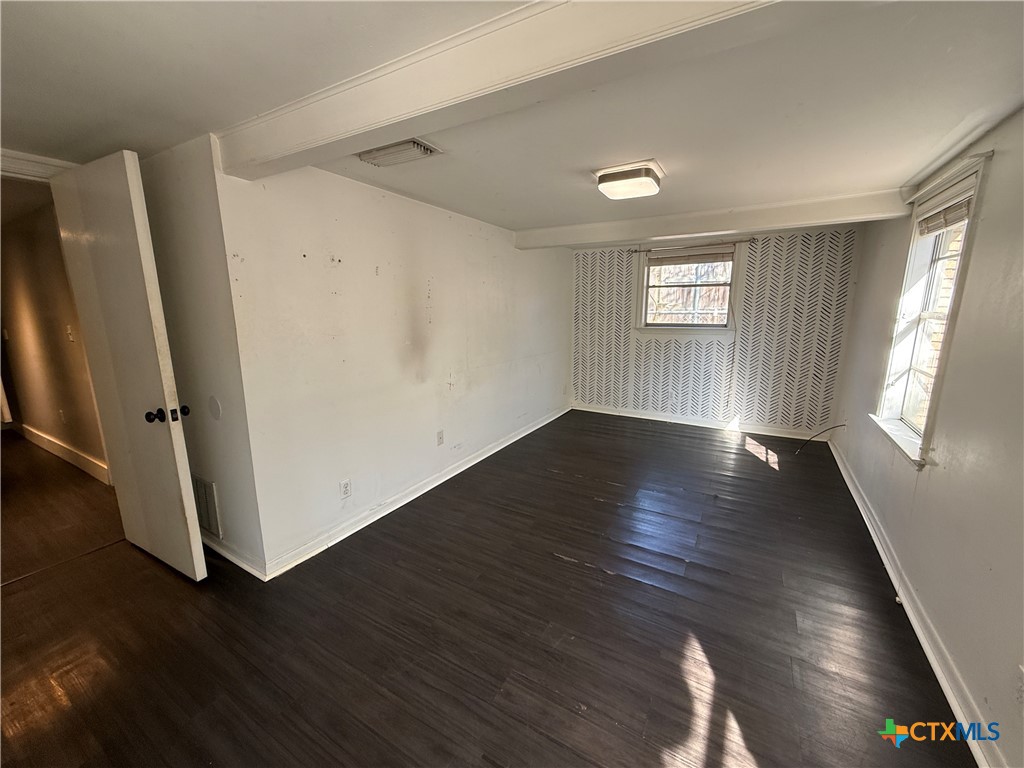 1701 North 13th Street Temple, TX 76501 - Photo 38 of 48 an empty room with wooden floor and windows