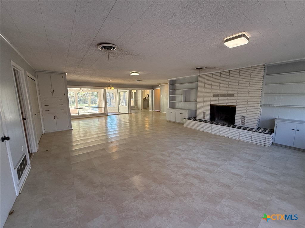 1701 North 13th Street Temple, TX 76501 - Photo 4 of 48 an empty room with fireplace and windows