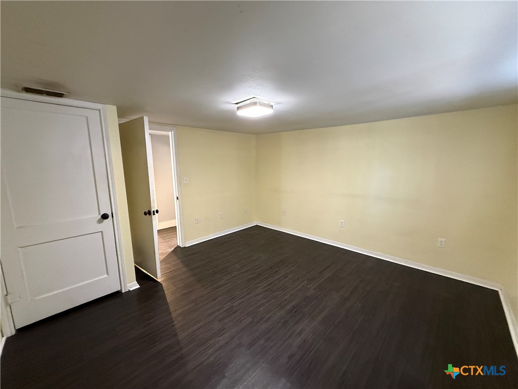 1701 North 13th Street Temple, TX 76501 - Photo 44 of 48 an empty room with wooden floor and a window