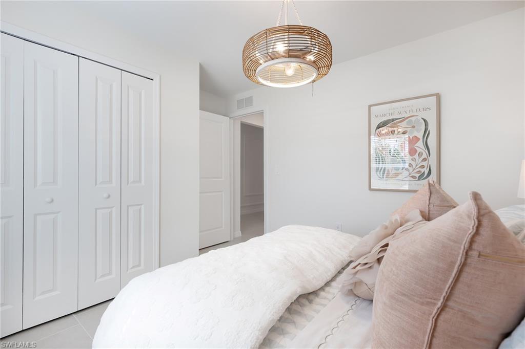 3717 40th Street Southwest Lehigh Acres, FL 33976 - Photo 15 of 30 a bedroom with a bed and a chandelier