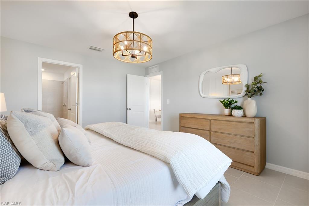 3717 40th Street Southwest Lehigh Acres, FL 33976 - Photo 20 of 30 a bedroom with a bed and a chandelier