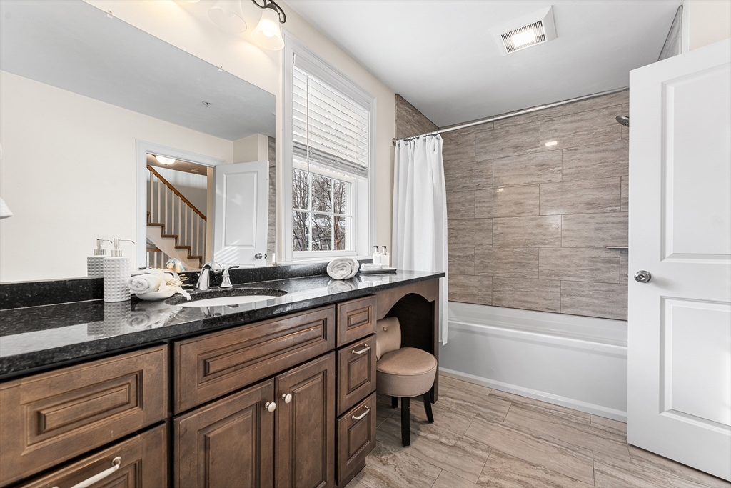 2 Mechanic Street, Unit 1 Medway, MA 02053 - Photo 17 of 32 a bathroom with a granite countertop sink a toilet a mirror and bathtub