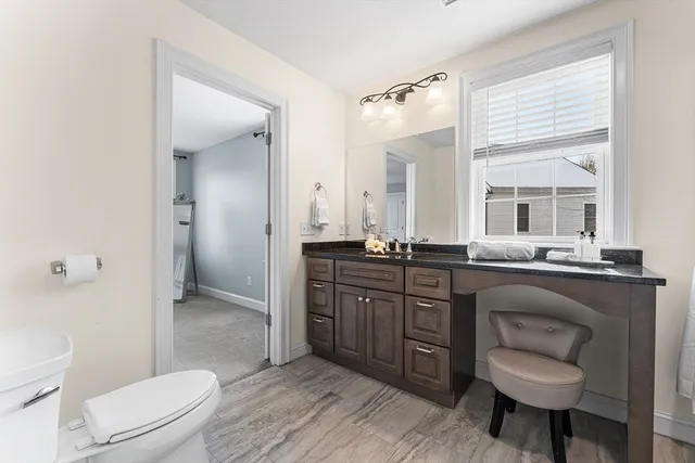 a bathroom with a granite countertop sink toilet a mirror and shower