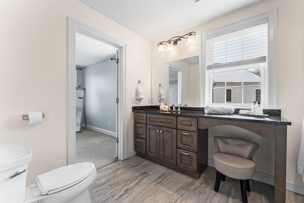 2 Mechanic Street, Unit 1 Medway, MA 02053 - Photo 18 of 32 a bathroom with a granite countertop sink toilet a mirror and shower