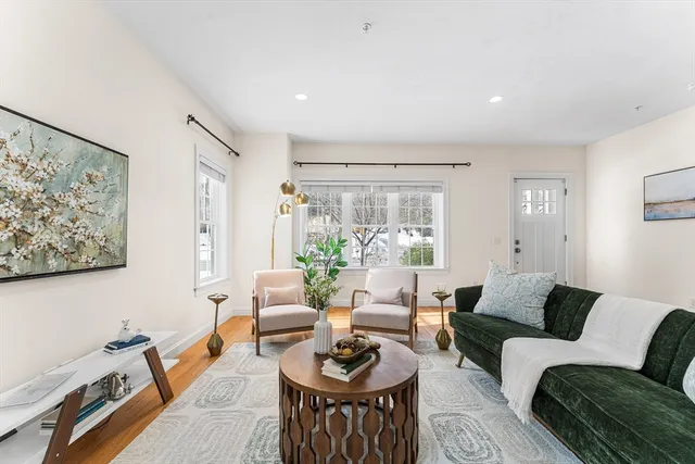 a living room with furniture a rug and a large window