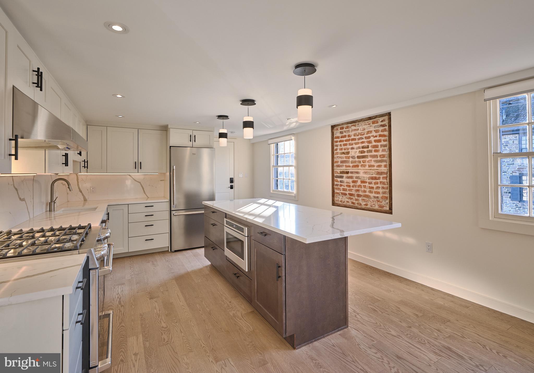 a kitchen with granite countertop a sink stove and cabinets