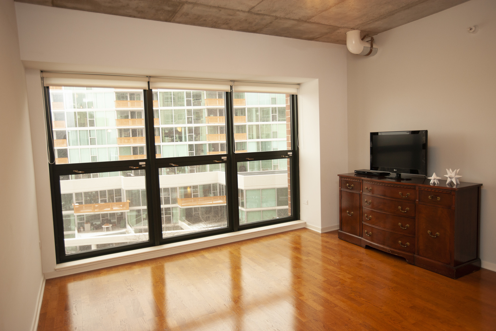 807 Davis Street, Unit 505 Evanston, IL 60201 - Photo 3 of 17 a view of an empty room with a flat screen tv and a window