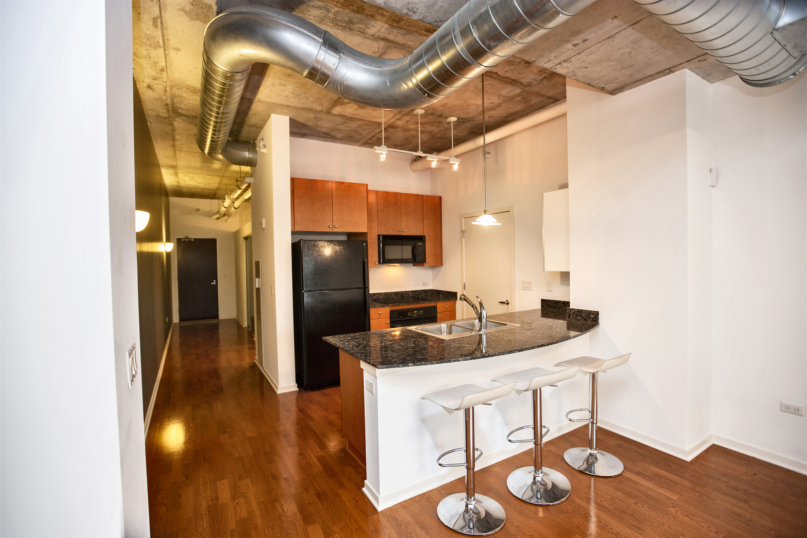 807 Davis Street, Unit 505 Evanston, IL 60201 - Photo 5 of 17 a kitchen with stainless steel appliances kitchen island granite countertop a table and chairs