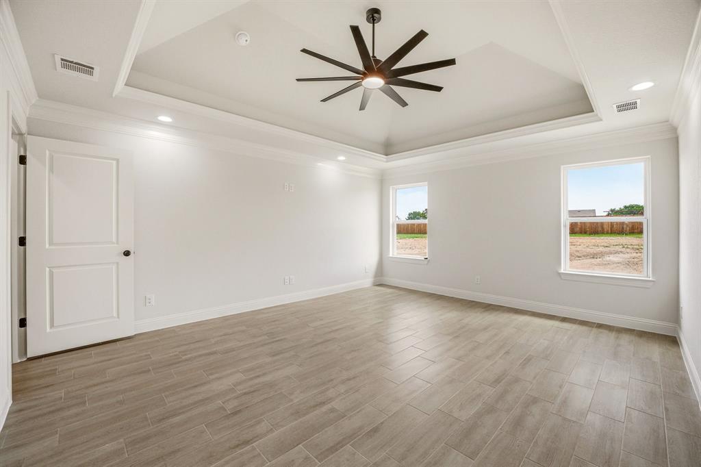 3155 Infinity Drive Weatherford, TX 76087 - Photo 20 of 39 Spare room with ceiling fan, wood finish floors, ornamental molding, recessed lighting, and a raised ceiling