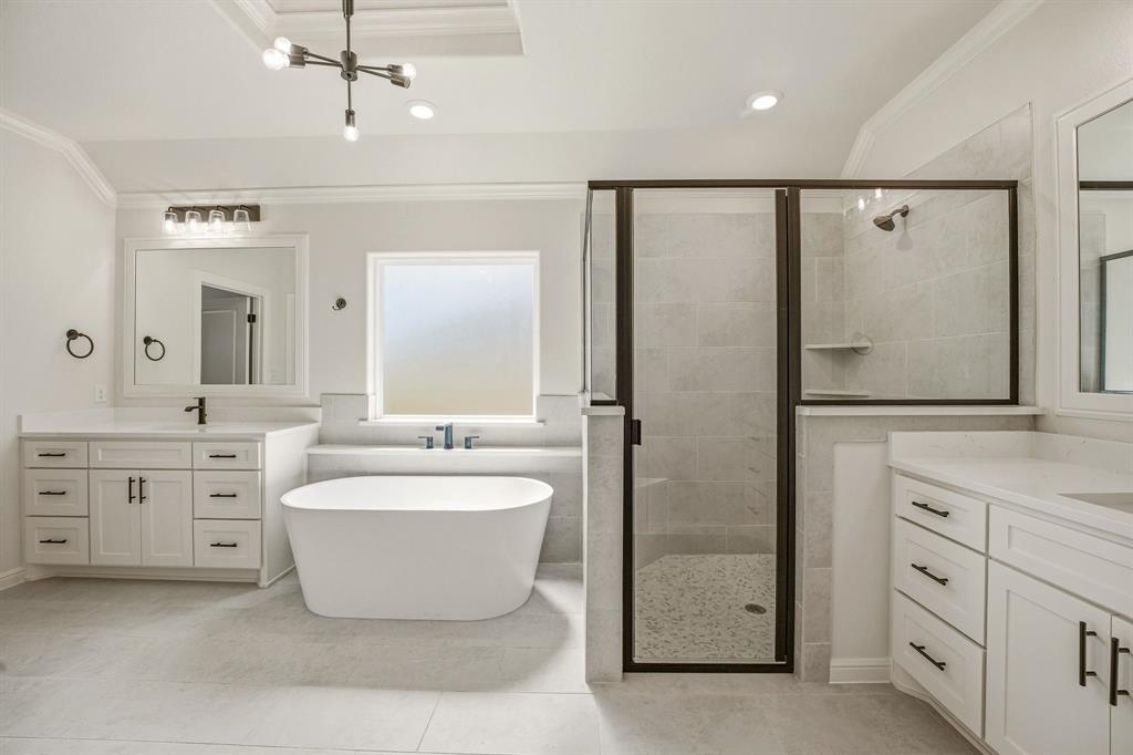 3155 Infinity Drive Weatherford, TX 76087 - Photo 22 of 39 Bathroom with two vanities, crown molding, a soaking tub, and a stall shower