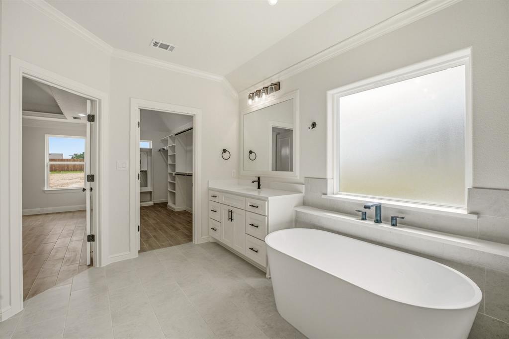 3155 Infinity Drive Weatherford, TX 76087 - Photo 23 of 39 Full bathroom with vanity, a spacious closet, crown molding, and a freestanding bath
