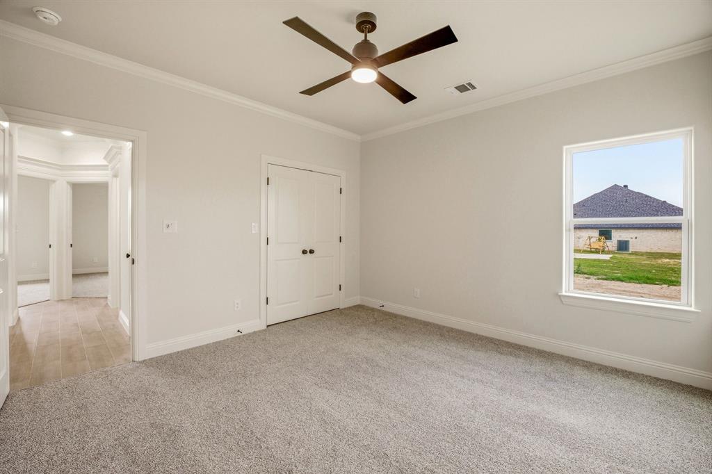 3155 Infinity Drive Weatherford, TX 76087 - Photo 32 of 39 Unfurnished bedroom featuring crown molding, light carpet, ceiling fan, and a closet