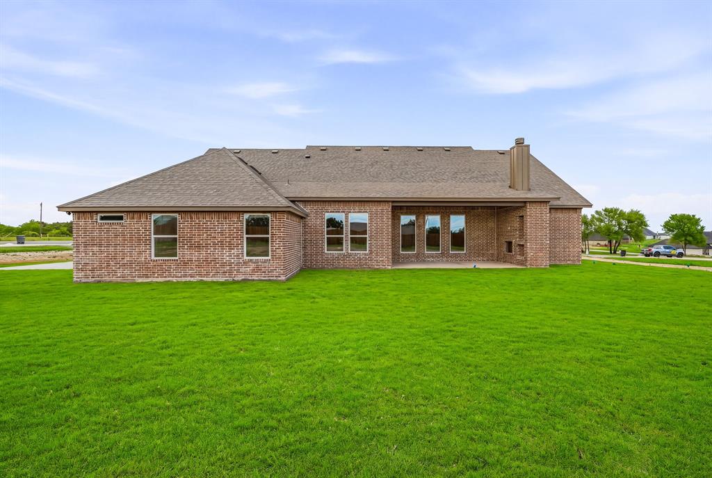 3155 Infinity Drive Weatherford, TX 76087 - Photo 35 of 39 Back of property with brick siding, roof with shingles, a chimney, a patio, and a yard