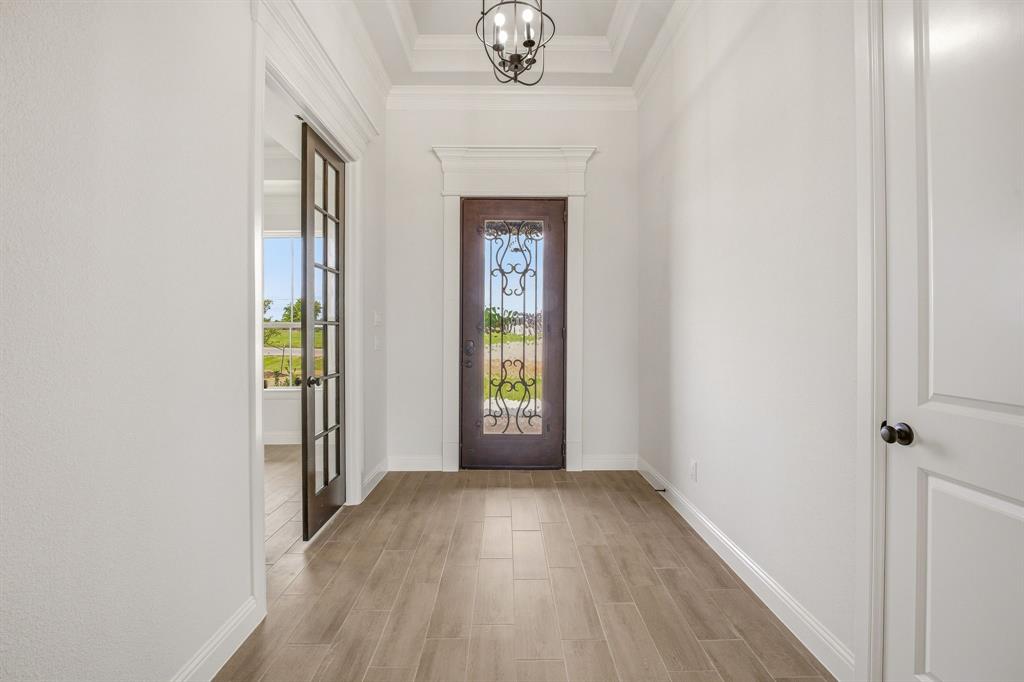 3155 Infinity Drive Weatherford, TX 76087 - Photo 4 of 39 Foyer entrance with wood tiled floors, hanging lights, and a raised ceiling
