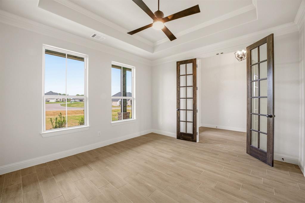 3155 Infinity Drive Weatherford, TX 76087 - Photo 6 of 39 Unfurnished room with french doors, wood tiled floors, ceiling fan, a raised ceiling, and crown molding
