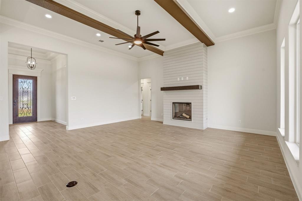 3155 Infinity Drive Weatherford, TX 76087 - Photo 10 of 39 Unfurnished living room with a ceiling fan, wood finish floors, beam ceiling, a fireplace, and recessed lighting