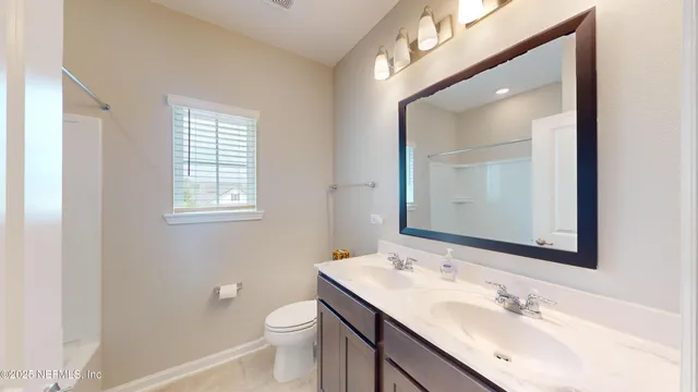 a bathroom with a sink a toilet and a mirror