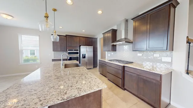 a large kitchen with kitchen island granite countertop a large counter top stainless steel appliances and cabinets