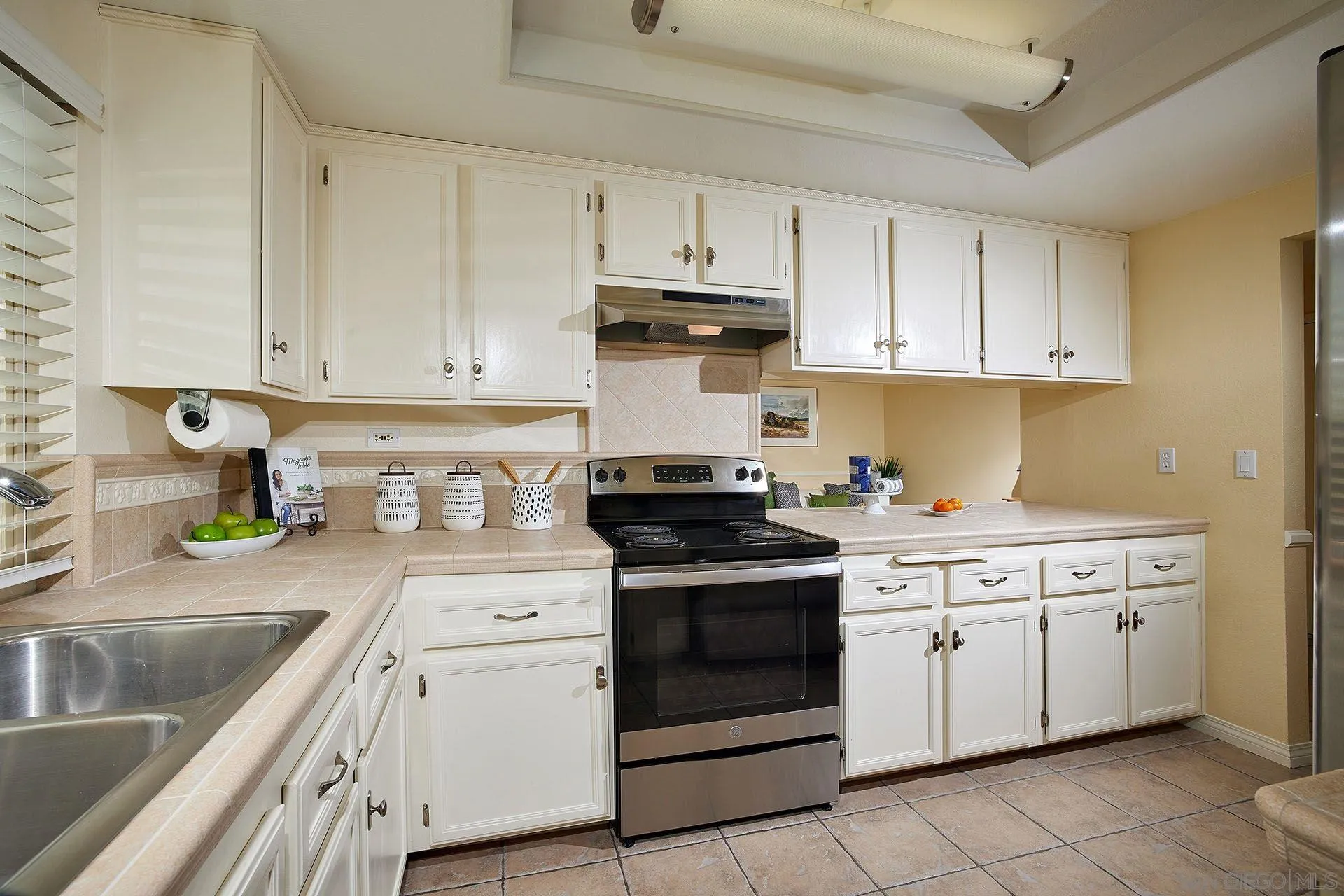 3007 Ruttles Court Spring Valley, CA 91978 - Photo 6 of 22 a kitchen with granite countertop white cabinets and white appliances