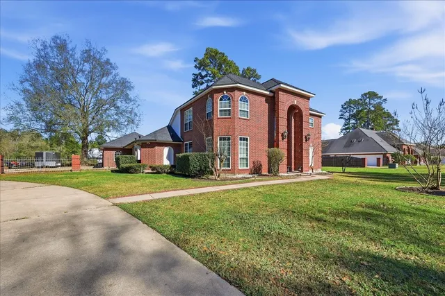 a view of a big house with a big yard and large trees