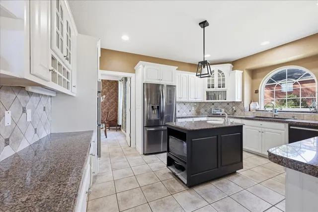 a kitchen with stainless steel appliances granite countertop a stove a sink and a refrigerator