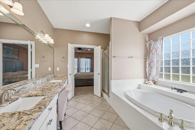 a spacious bathroom with a granite countertop tub sink and mirror