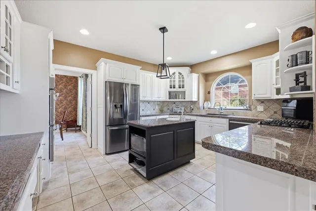 a kitchen with stainless steel appliances granite countertop a stove and a sink