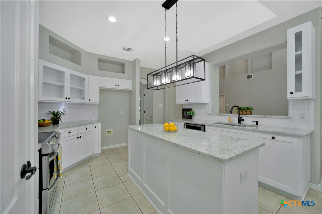 103 Sierra Ridge Drive San Marcos, TX 78666 - Photo 16 of 43 a kitchen with stainless steel appliances a sink stove and refrigerator