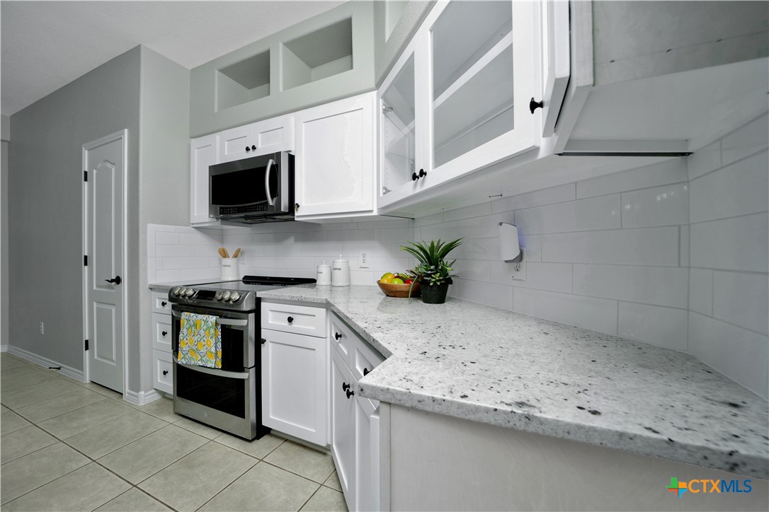 103 Sierra Ridge Drive San Marcos, TX 78666 - Photo 17 of 43 a kitchen with stainless steel appliances granite countertop a sink and a stove