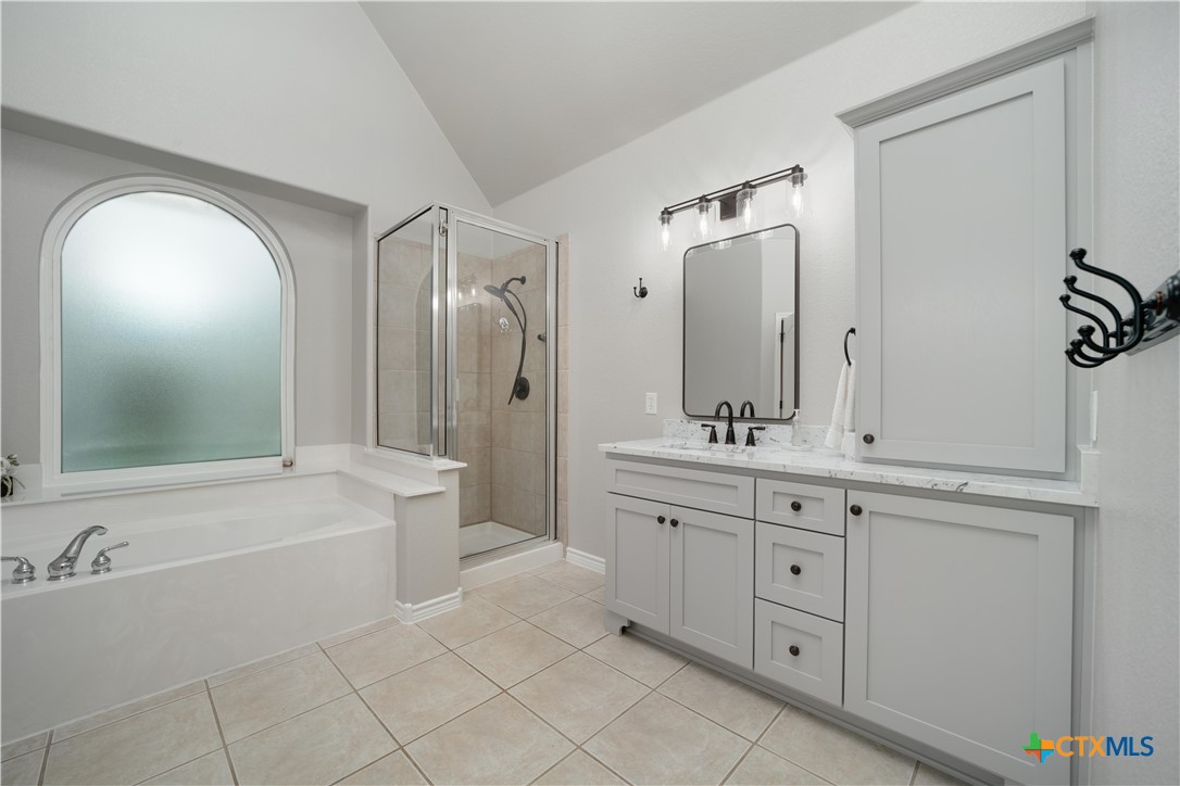 103 Sierra Ridge Drive San Marcos, TX 78666 - Photo 27 of 43 a bathroom with a tub a sink and a mirror