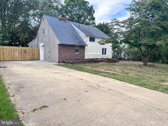 a view of a house with a yard and large tree
