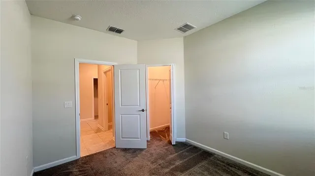 a view of an empty room with a kitchen