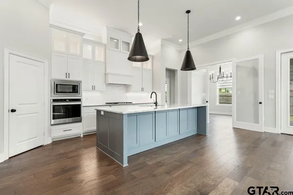 a kitchen with stainless steel appliances granite countertop a stove a sink and a wooden floors