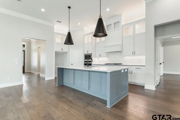 a kitchen with white cabinets and window