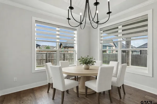 a dining room with furniture a chandelier and wooden floor