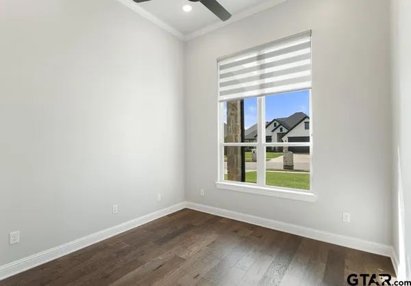 an empty room with wooden floor and a window