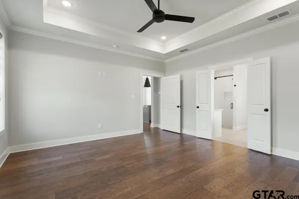 a view of an empty room with wooden floor