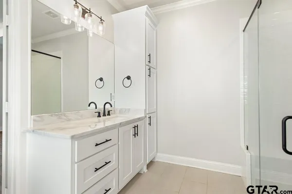 a bathroom with a granite countertop sink a mirror and shower