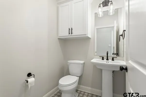 a bathroom with a sink mirror and toilet