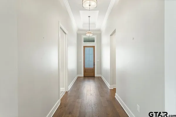 a view of a hallway with wooden floor and staircase